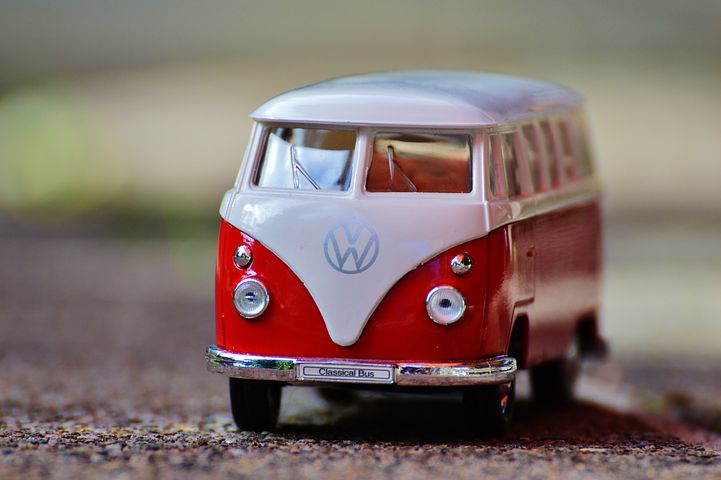 Valko-punainen minibussi hiekalla. Lasten lelu.